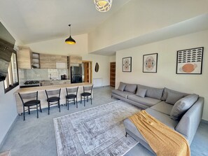 A modern living space with a kitchen, dining area, and a sofa set. - Faqra Chalets by Stayinn (Faqra)
