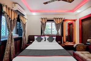 A hotel room with a bed, curtains, a window, a ceiling fan, and a door. - Hotel O THE CROWN COMFORTS (Bidhannagar)