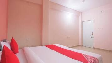 A hotel room with a bed, a door, and a ceiling fan.