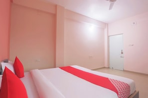 Una habitación de hotel con una cama, una puerta y un ventilador de techo.