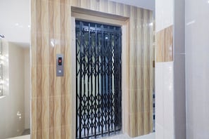 Um elevador com visor digital e portão de segurança em metal.