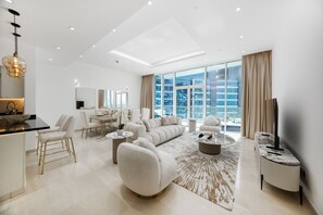 A modern living room with a sofa, coffee table, and dining area. - Refined 1BR Haven | Palm Jumeirah (Dubai)