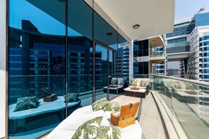 Ein moderner Außenbereich mit Glaswänden, Sitzgelegenheiten und Blick auf die Stadtlandschaft.