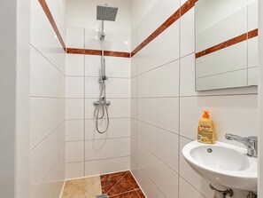 A bathroom with a shower, a sink, and a mirror. - Vienna Hideaway 1BR near Westbahnhof (Wien)