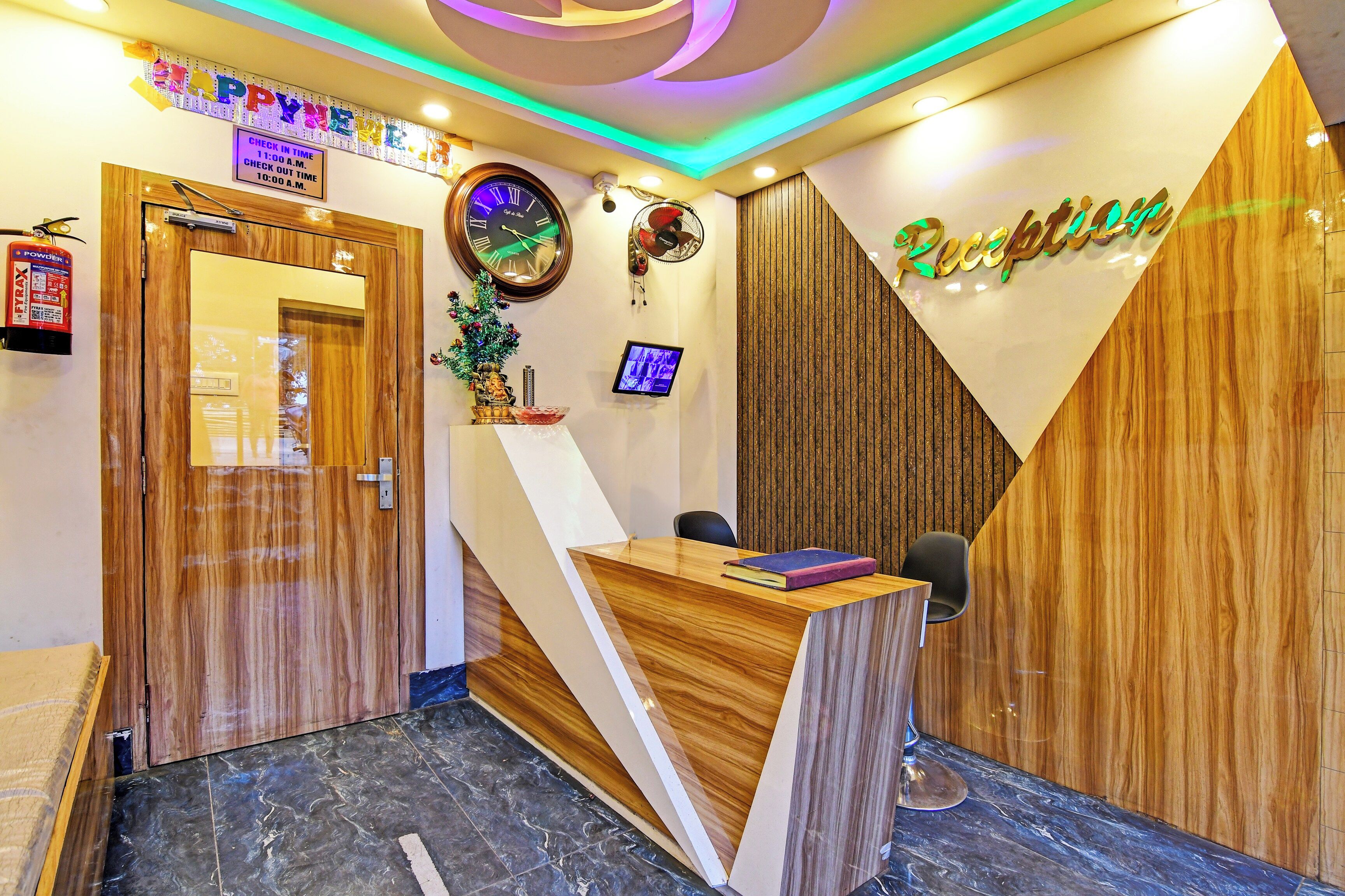 A reception desk with a wooden finish, a wall clock, and a reception sign.