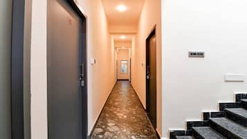 A hallway with a marble floor leading to a staircase.