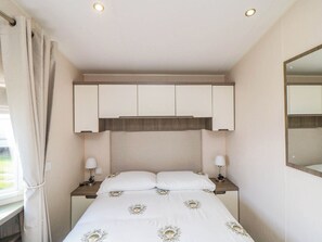 A bedroom with a bed, nightstands, a mirror, and a window with curtains. - Gosling 14 (Scarborough)