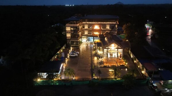 A multi-story hotel with a prominent entrance and a parking area.