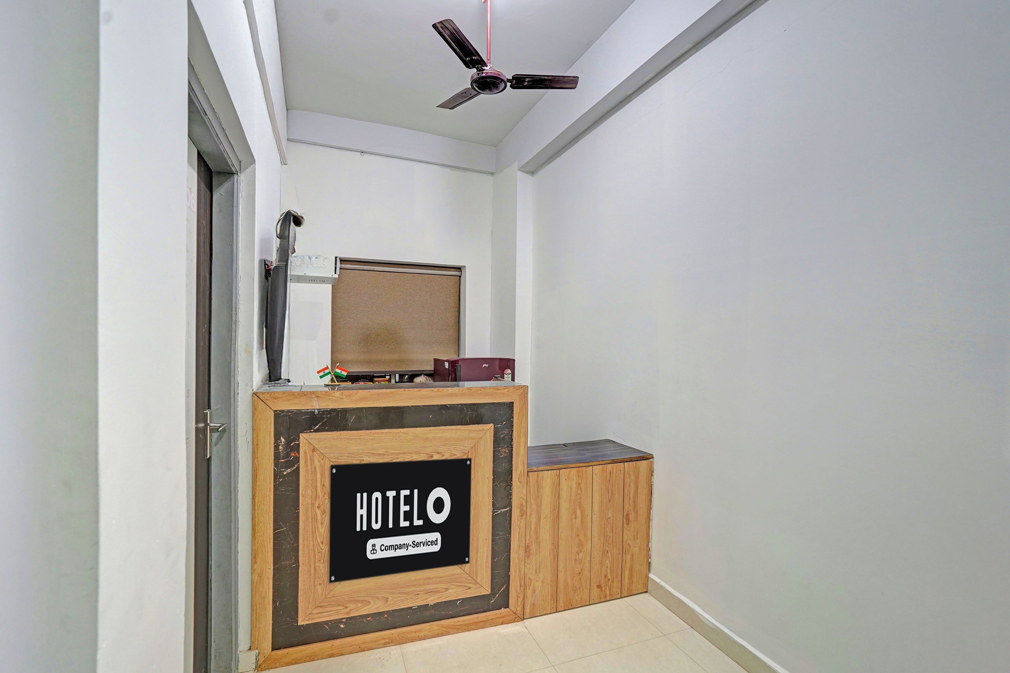 Mostrador de recepción de hotel con un cartel que dice 'HOTEL' y 'Servicio de la empresa'.