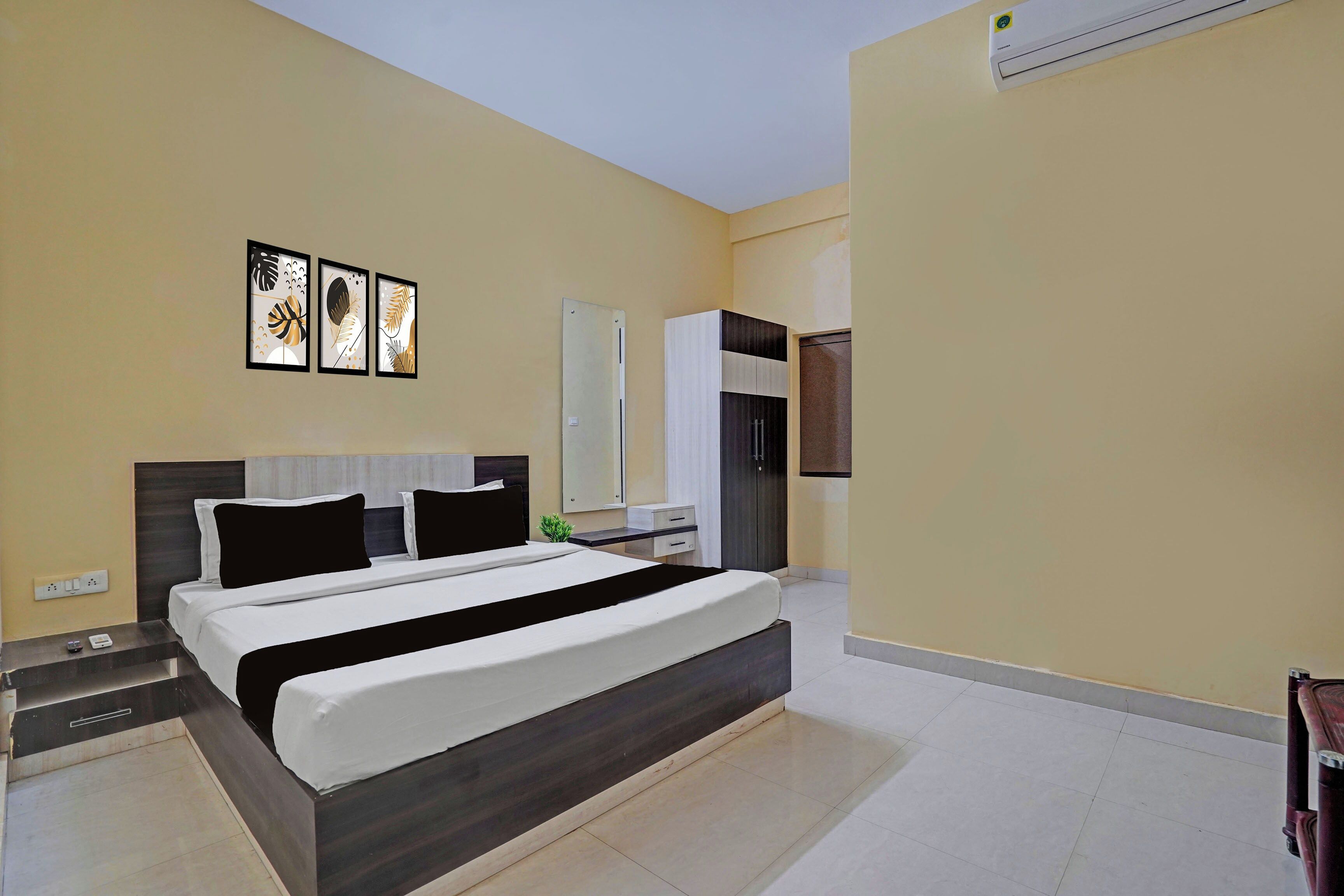 Un dormitorio moderno con una cama grande, mesitas de noche, un armario y un espejo.