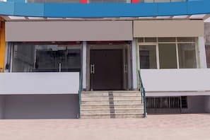 Entrada de um edifício moderno, com um conjunto de degraus a levar a uma porta.
