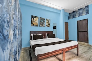 A hotel room with a bed, artwork on the wall, a door, and a window. - Collection O JECC Jaipur (Jaipur)