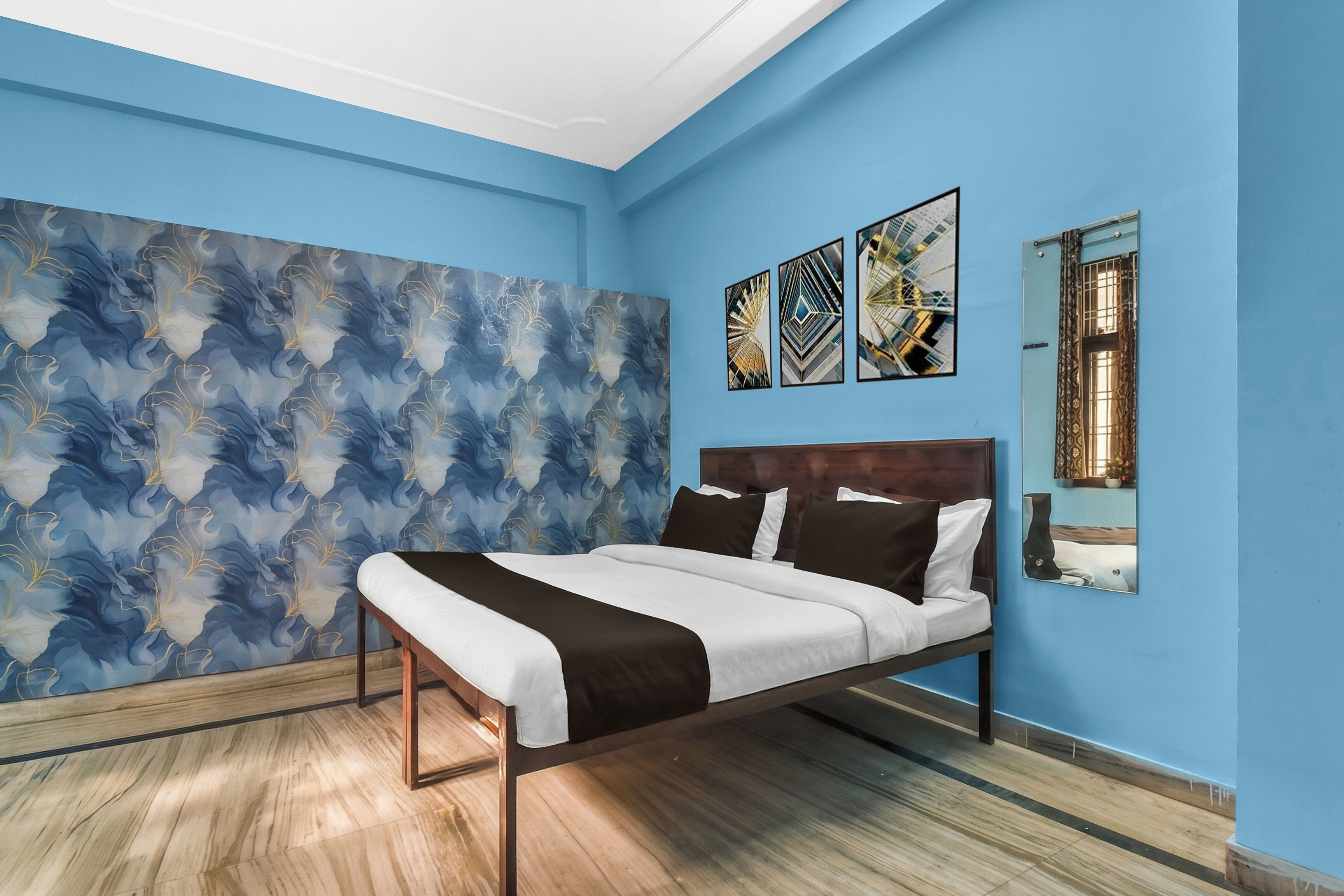 A bedroom with a bed, a large abstract wall mural, and three framed artworks.