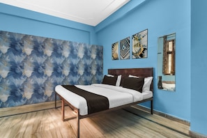 A bedroom with a bed, a large abstract wall mural, and three framed artworks. - Collection O JECC Jaipur (Jaipur)