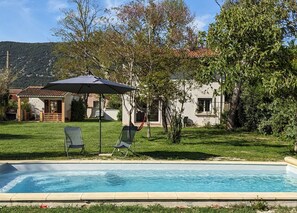 A swimming pool with two lounge chairs and an umbrella, surrounded by a well-maintained lawn and trees. - Holiday Home 'La Valkyrie' with Mountain View, Wi-Fi and Air Conditioning (Caudiès-de-Fenouillèdes)