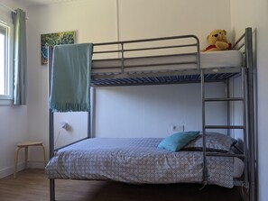 A bunk bed with a patterned bedspread, a small stool, and a teddy bear on the top bunk. - Holiday Home 'La Valkyrie' with Mountain View, Wi-Fi and Air Conditioning (Caudiès-de-Fenouillèdes)