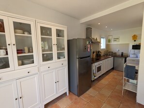 A kitchen with white cabinetry, a stainless steel refrigerator, and a tiled floor. - Holiday Home 'La Valkyrie' with Mountain View, Wi-Fi and Air Conditioning (Caudiès-de-Fenouillèdes)