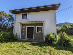A two-story house with a stone facade, a brown door, and a small window on the upper floor. - Holiday Home 'La Valkyrie' with Mountain View, Wi-Fi and Air Conditioning (Caudiès-de-Fenouillèdes)