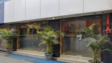 A building with large glass windows, potted plants, and a 'CLOSE' sign on the door.