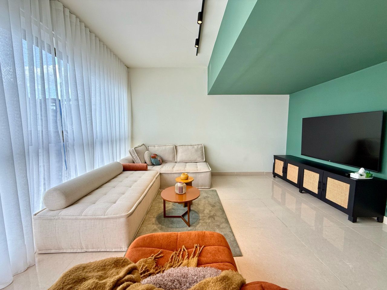 A modern living room with a sectional sofa, a coffee table, and a TV stand.
