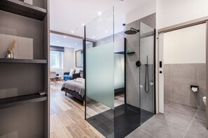 Et moderne badeværelse med et glasbadeværelsesafskærmning, toilet og vask.
