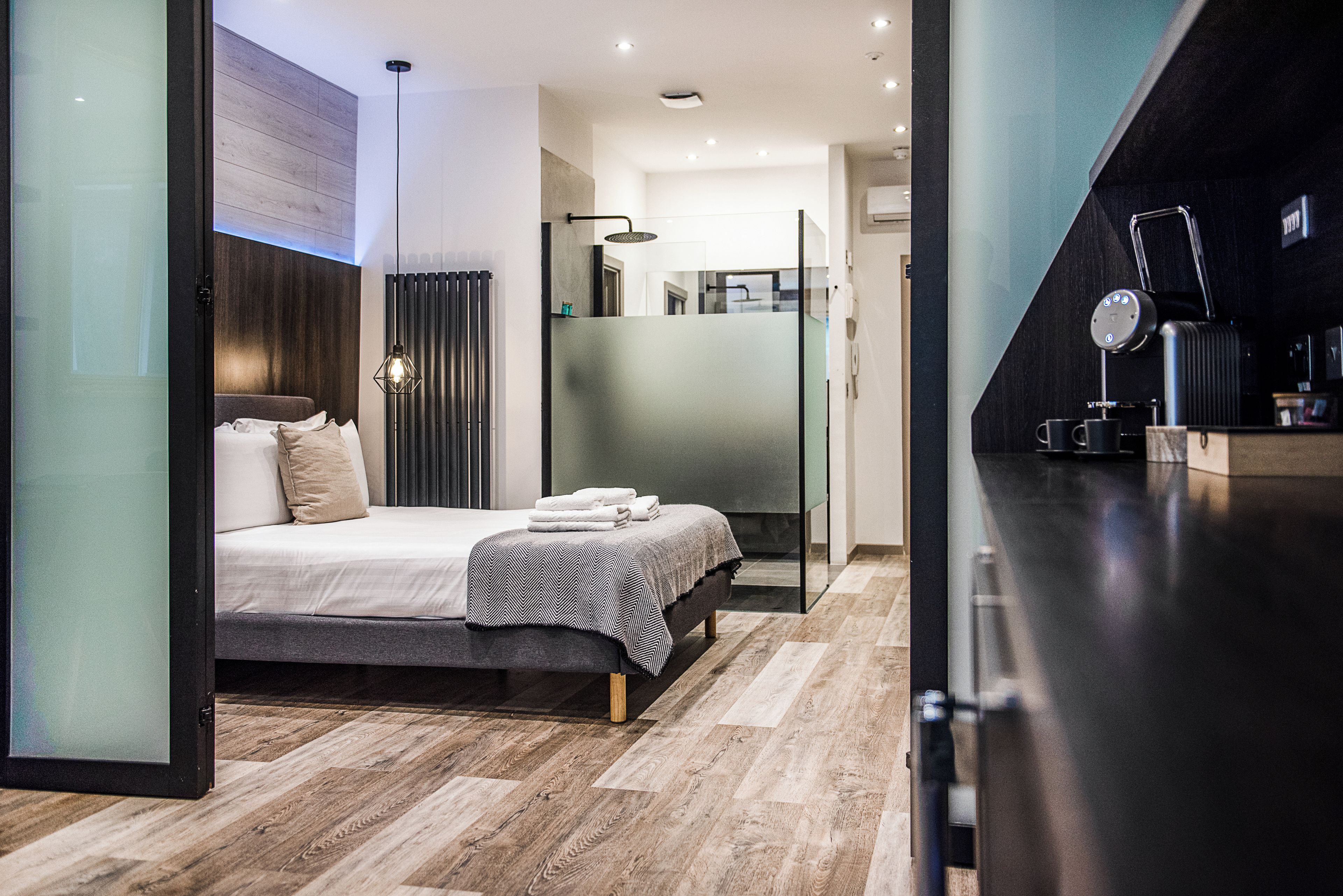 Un dormitorio moderno con cama, mesita de noche y espejo.