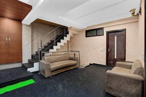 Un interior moderno con una escalera, un sofá y una puerta.