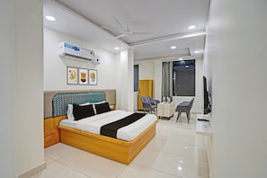 A modern hotel room with a bed, desk, chair, and a television. - Townhouse Oak Sun City Mall Hisar (Hisar)