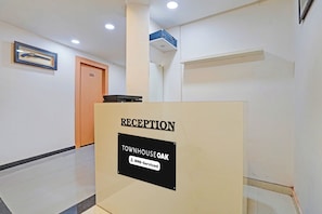 A reception desk with a sign indicating it is for the Townhouse and is serviced by 6YO. - Townhouse Oak Sun City Mall Hisar (Hisar)