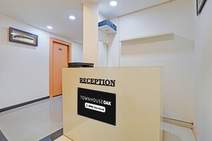 A reception desk with a sign indicating it is for the Townhouse and is serviced by 6YO.