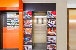 An elevator with a 24/7 open sign, surrounded by images of hotel rooms and amenities.
