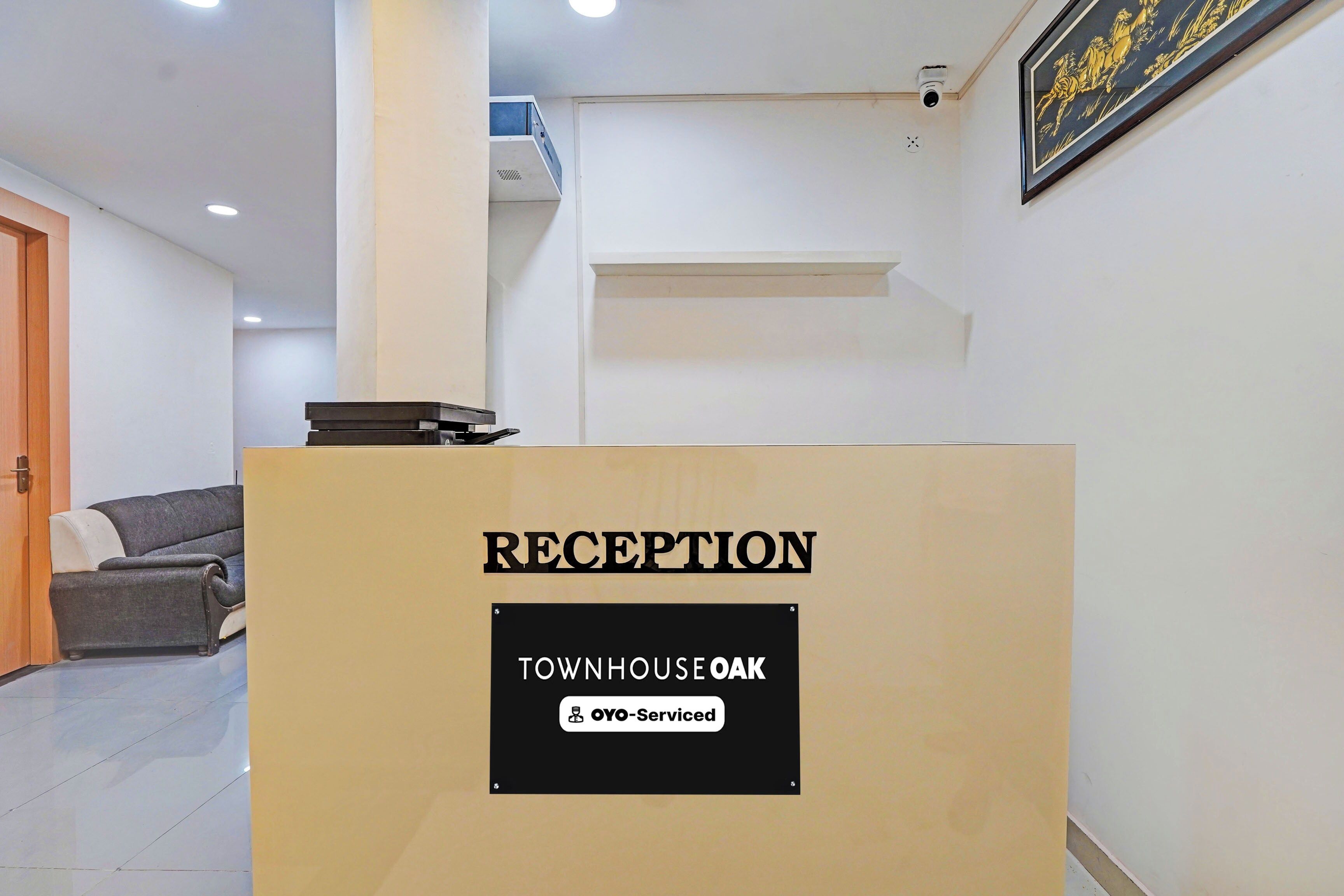 A reception desk with a sign indicating 'RECEPTION' and 'TOWNHOUSE OAK' with a logo for 'OYO-Serviced'.