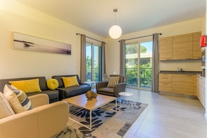 Una sala de estar moderna con un sofá, sillones, una mesa de centro y un cuadro en la pared.
