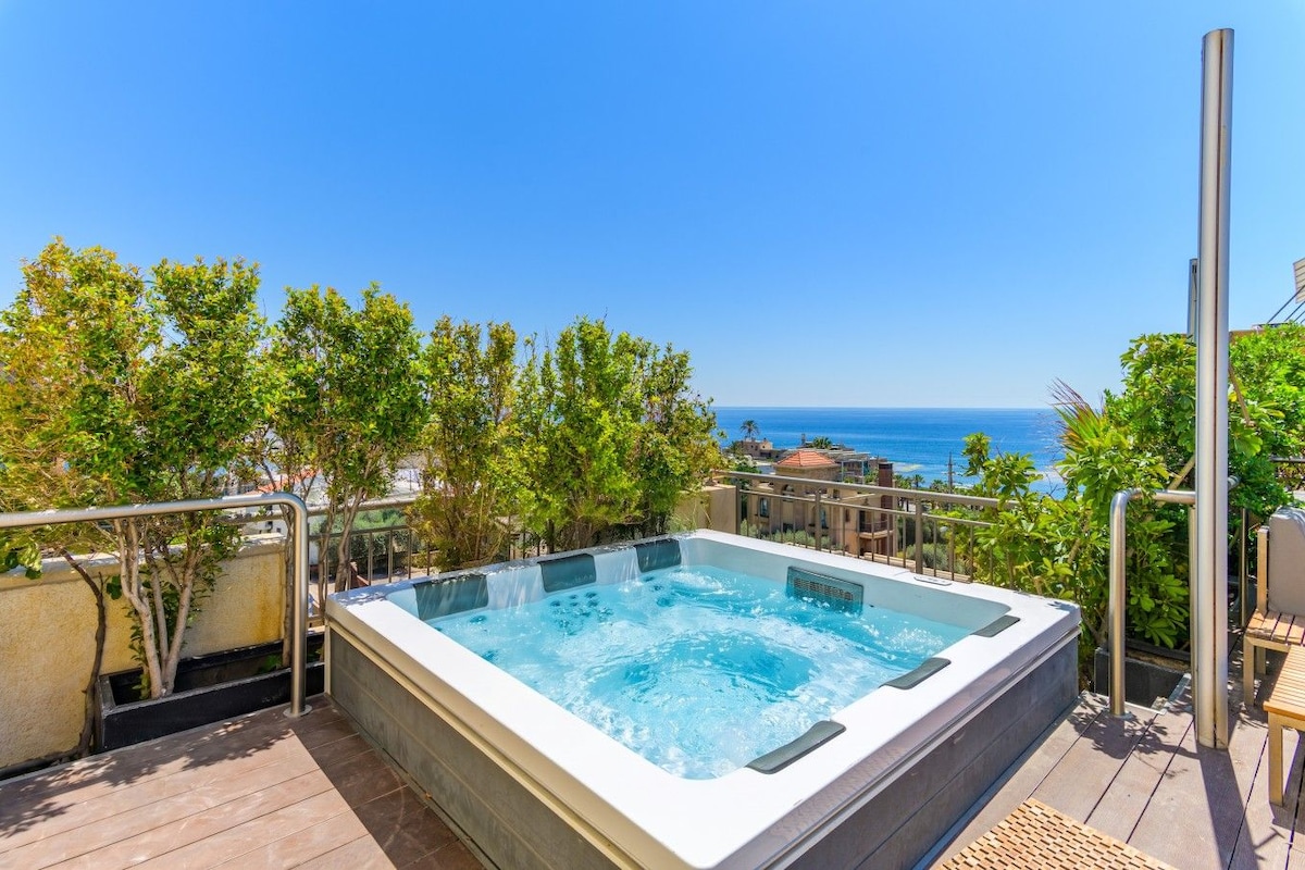 Un jacuzzi en una terraza con vista al océano.