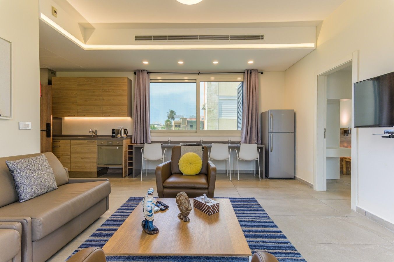 Una sala moderna con un sofá, una mesa de centro y un comedor con sillas.