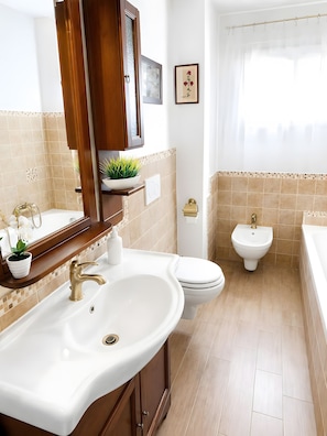 Un baño con lavamanos, inodoro, bidé y bañera.