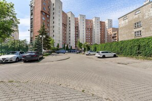 Ein Parkplatz mit mehreren Autos, umgeben von hohen Wohnhäusern.