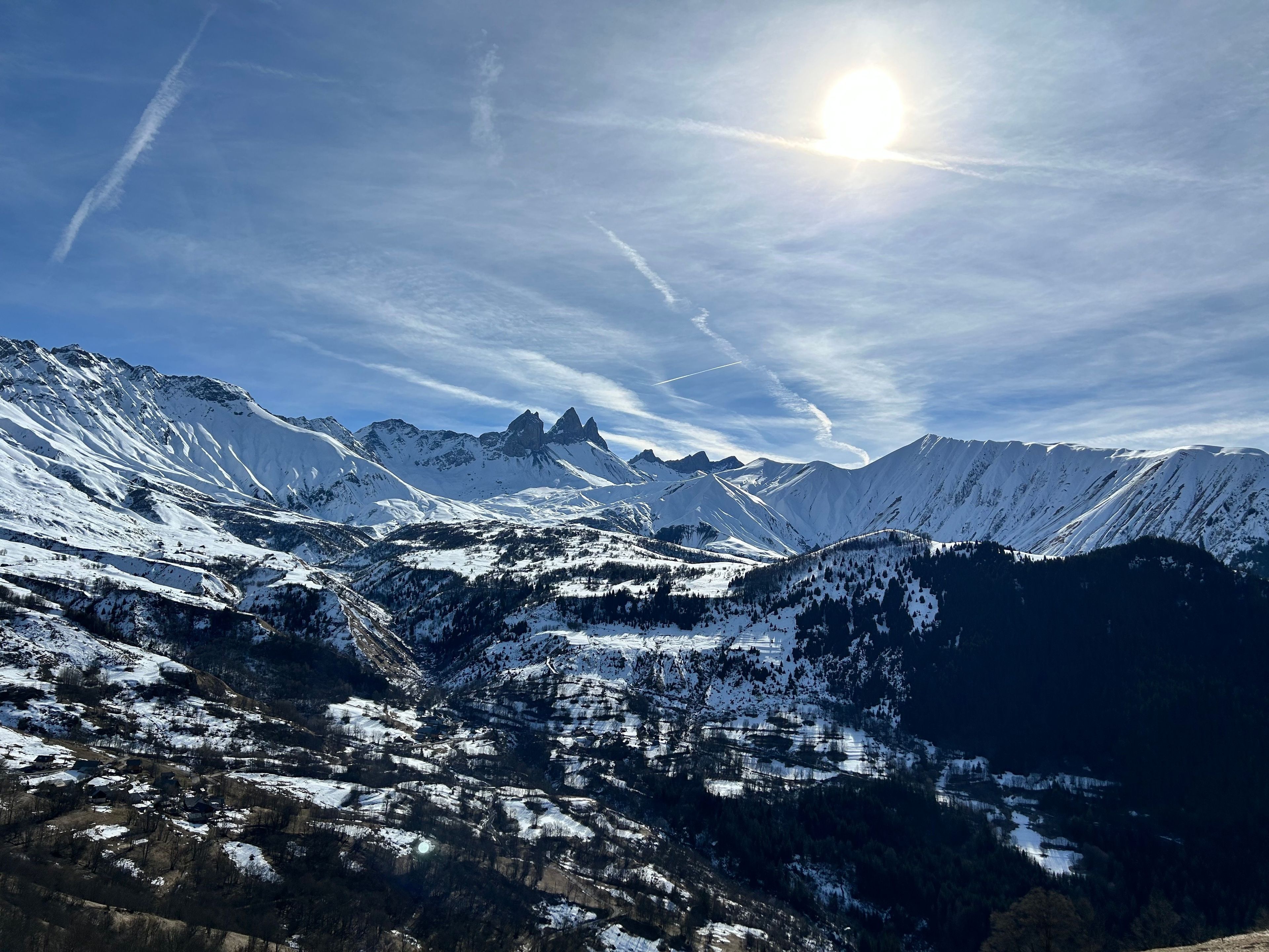 Un paysage montagneux aux sommets enneigés, sous un ciel dégagé.