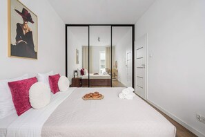 A hotel room with a bed, a breakfast tray, and a view into the bathroom. - Central Flat near Manufaktura (Łódź)