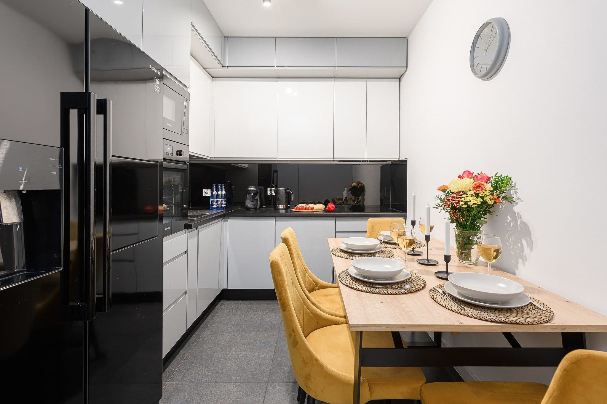 Una cocina moderna con comedor, equipada con refrigerador, estufa y cafetera.