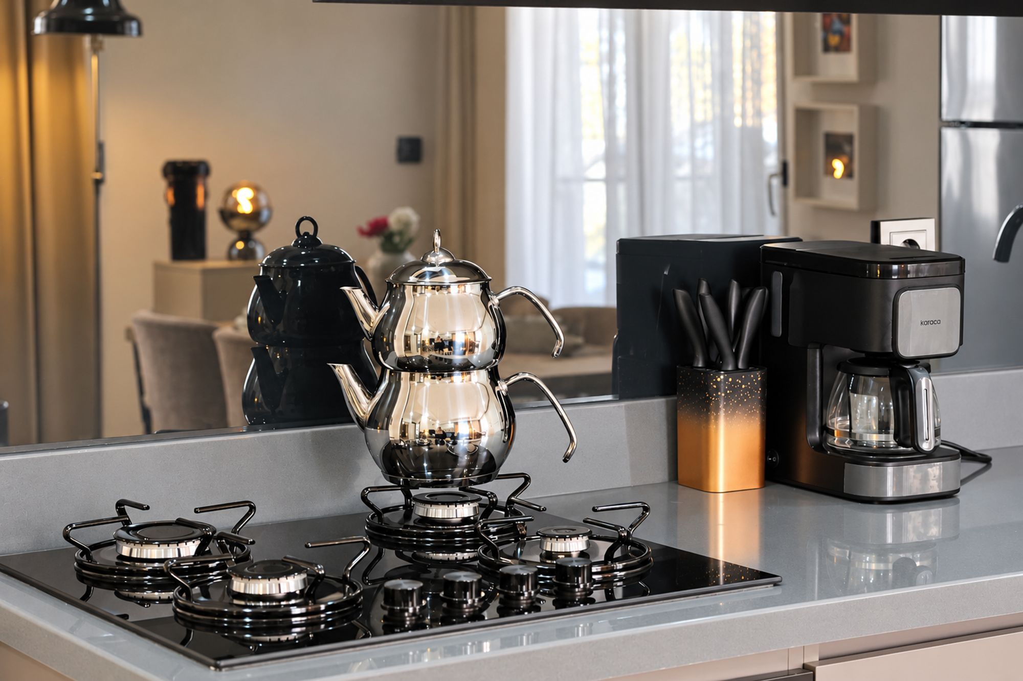 A modern kitchen with a gas stove, a coffee maker, and a kettle.