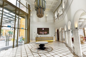A lobby with a reception desk, a chandelier, and a tiled floor. - Rei Gallery Appartments Hillside (Phu Quoc)