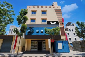 Un hotel amb una façana moderna, moltes finestres i un rètol que indica que és un hotel de servei per a empreses.