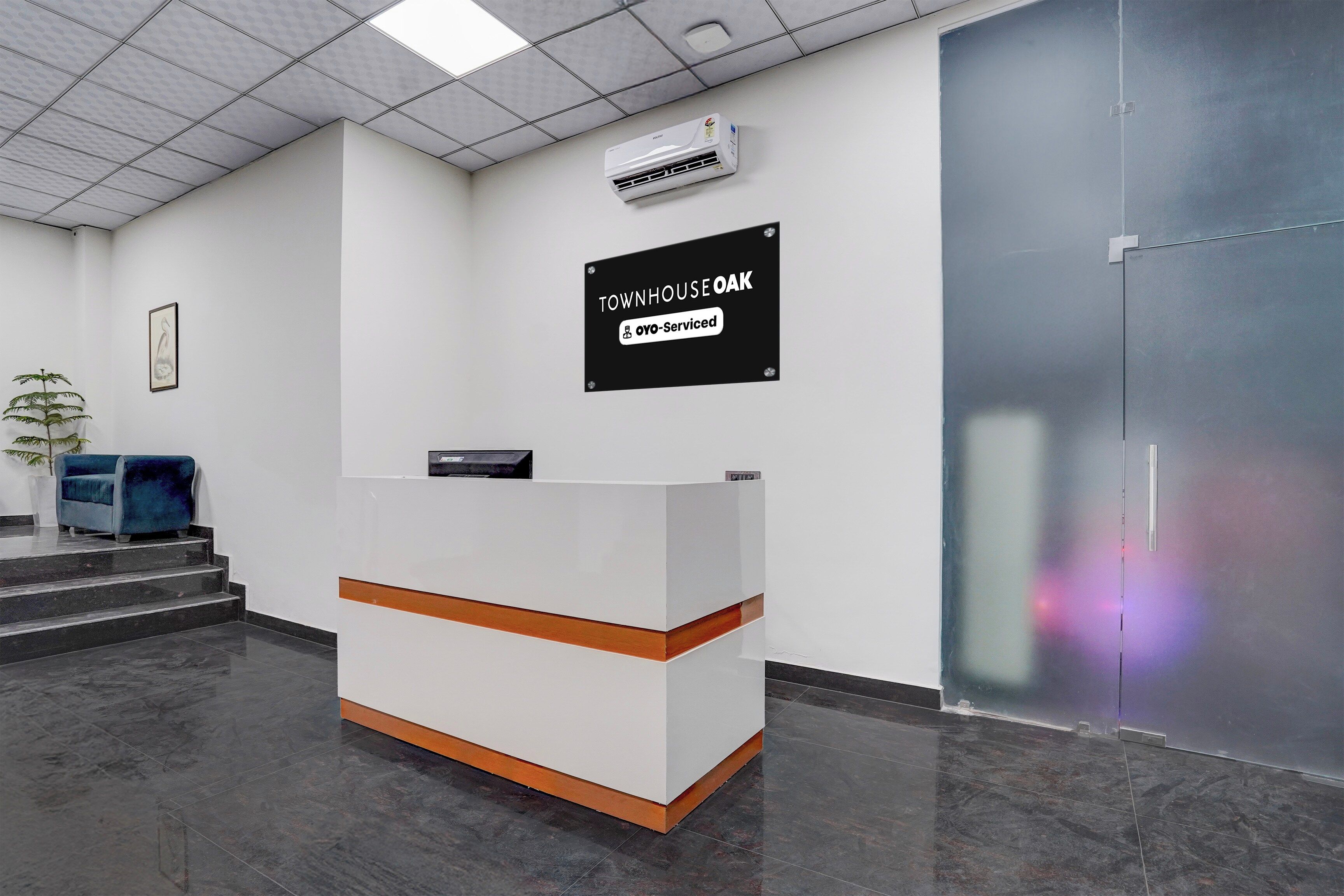 A reception desk with a sign indicating 'TOWNHOUSE OAK' and 'oyo-Serviced'.