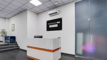A reception desk with a sign indicating 'TOWNHOUSE OAK' and 'oyo-Serviced'.