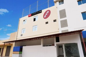 Um hotel com vários andares e uma placa vermelha destacada que indica um aplicativo de reservas.
