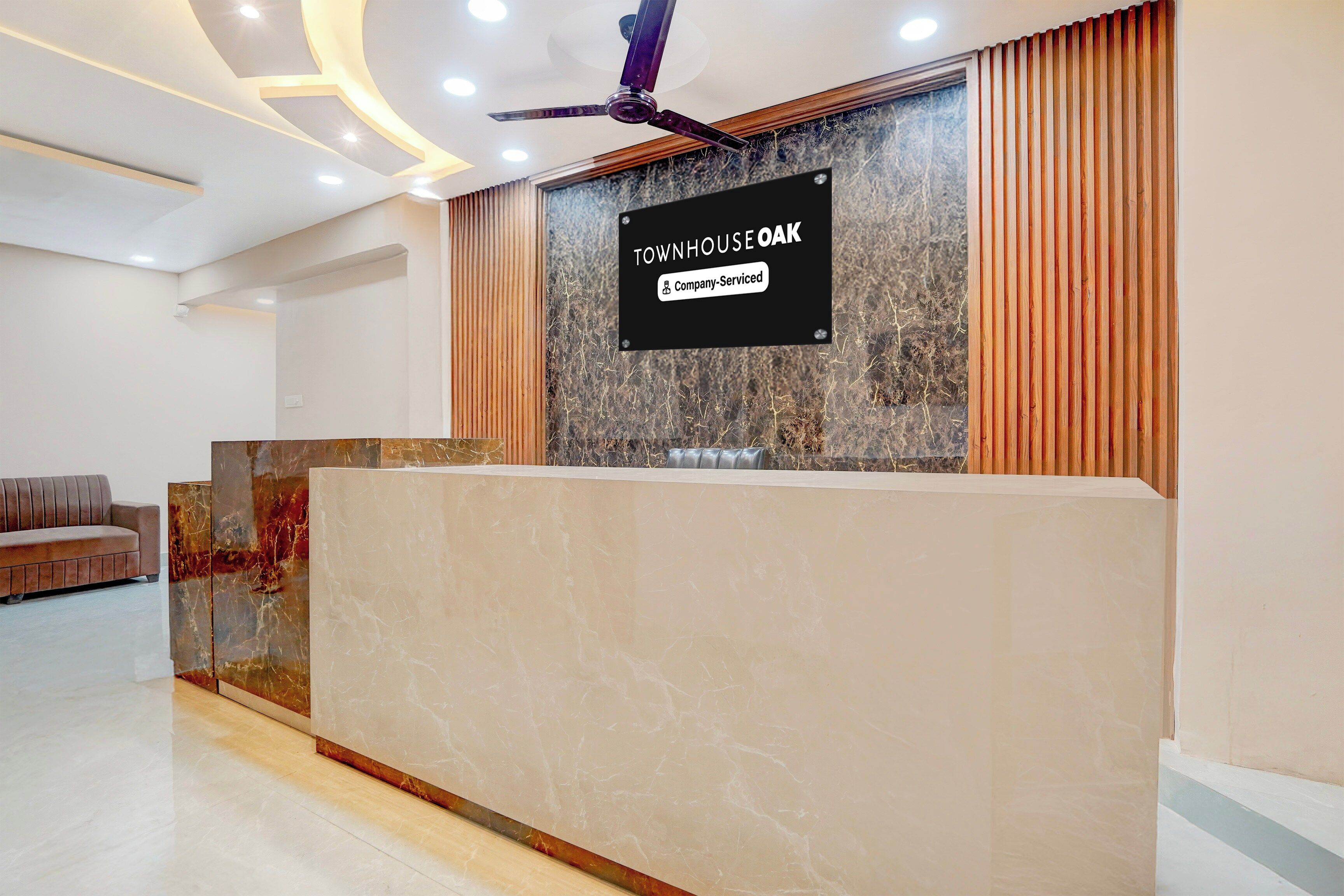 Una mesa de recepción con un cartel que indica 'TOWNHOUSE OAK' y 'Servicios para empresas'.