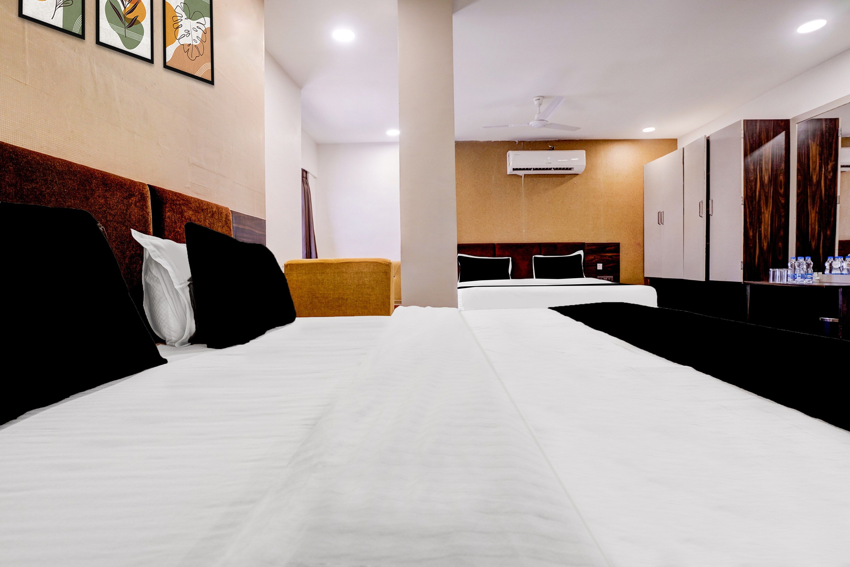 Una habitación de hotel con una cama grande, un sofá pequeño, un escritorio con espejo y un armario.