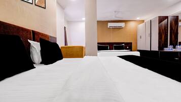 Una habitación de hotel con una cama grande, un sofá pequeño, un escritorio con espejo y un armario.