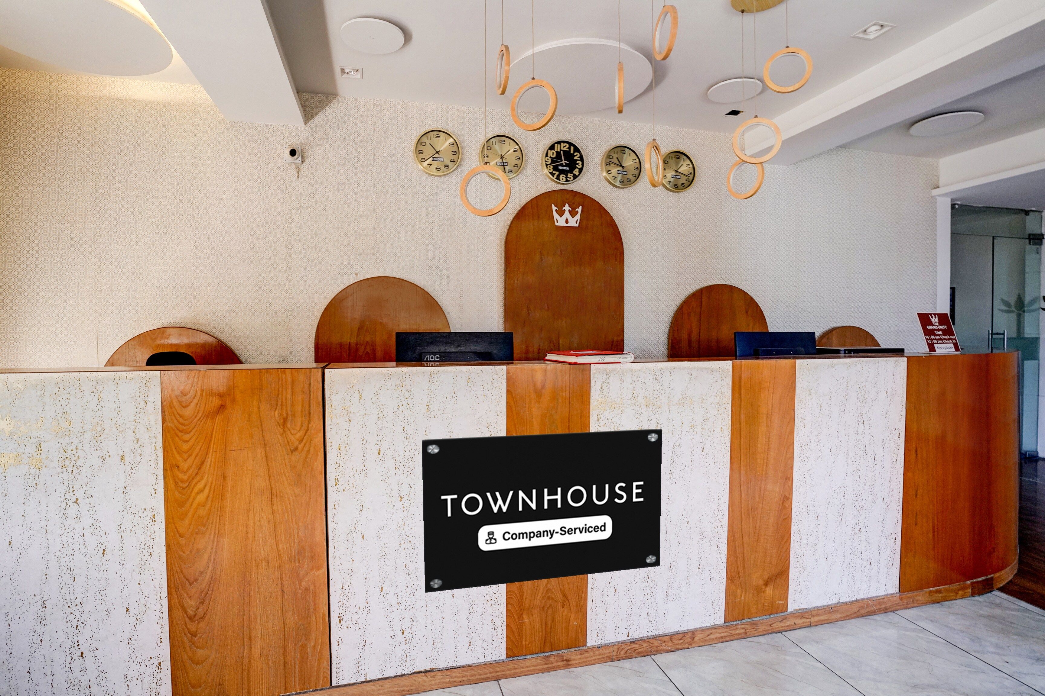A reception desk with a sign reading 'TOWNHOUSE Company-Serviced'.